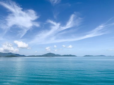 Mavi ocen ve beyaz bulutlu mavi gökyüzünün güzel yüzeyi