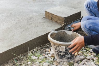 İşçi beton zemini mala kullanarak düzleştiriyor
