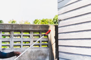 Boyacı duvarları beyaz boyayla boyuyor.