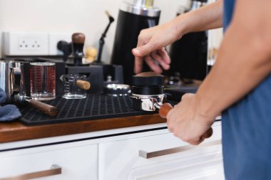Barista iskele tarafındaki filtreye kahve döküyor.