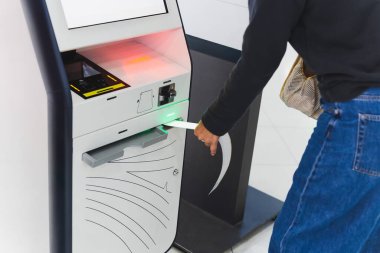 Havaalanındaki makinede self servis kontrolü kullanan bir kadın gezgin.