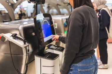 Havaalanına giriş yapmak için servis makinesini kullanan kadın.