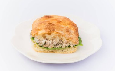 Ciabatta ekmeğine salatalı ton balığı sandviçi, beyaz arka planda.