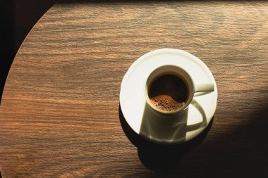 Tahta bir masanın üstünde bir fincanda espresso.