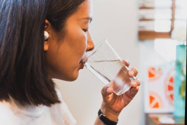 Kadın bardaktan taze soğuk su içiyor.