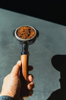Kahveci elinde portafilter sepetinde kahve tozu tutuyordu.