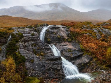 Glencoe (İskoçya) arka planda dağlar olan şelale