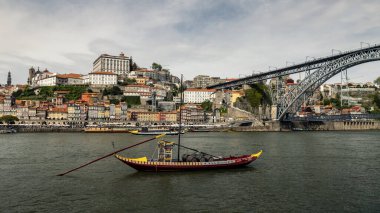Arka planda Porto (Portekiz) şehrinin bulunduğu Douro Nehri 'ndeki tipik bir asi teknesi.