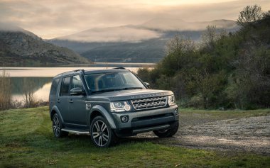 Güneş doğarken gölün kenarında 4x4 SUV 'a konaklama lüksü