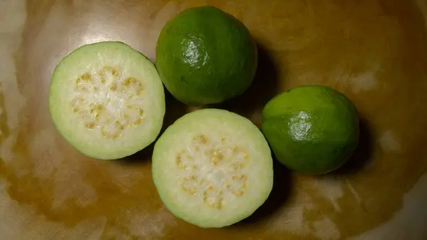 Tahta bir masada dilimlenmiş elma guava grubu.