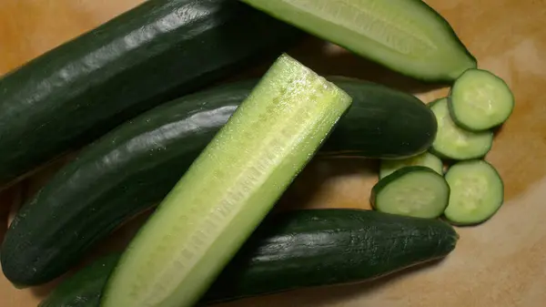 Tahta bir masada dilimlenmiş bir grup Avrupa salatalığı.