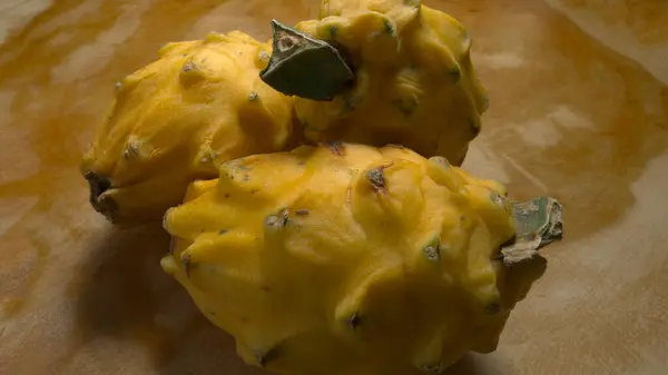 Tahta bir masanın üzerinde bir grup ejderha meyvesi.