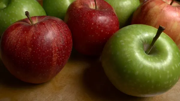 Tahta bir masanın üzerinde bir grup yeşil elma.