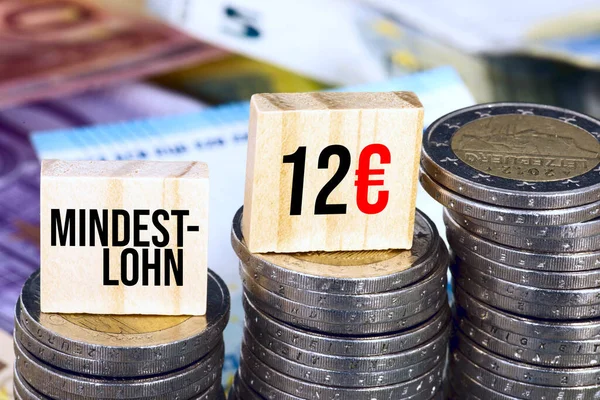 ドイツ語で最低賃金12ユーロの碑文を持つユーロ硬貨の山のクローズアップショット ロイヤリティフリーのストック写真