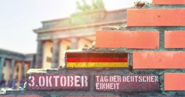 Berlin duvarında Almanya 'nın birlik günü ve Alman bayrağı sembolü yazılı. Brandenburg kapısı arka planda