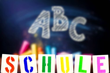 ABC harfli tebeşir tahtası ve Almanca 'da okul anlamına gelen renkli harfler.