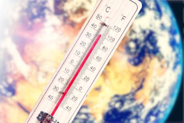 Dünya gezegeni ve yazın iklim değişikliği ve küresel ısınmanın sembolü olarak bir termometre.