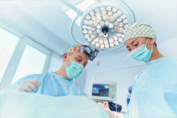 手術室で働くチーム外科医 ロイヤリティフリーのストック写真