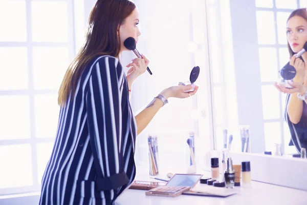 Güzel Kız Aynaya Bakıyor Büyük Bir Fırçayla Kozmetik Uyguluyor — Stok fotoğraf