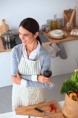 Mutfakta bilgisayar ve kredi kartı kullanan gülümseyen bir kadın..