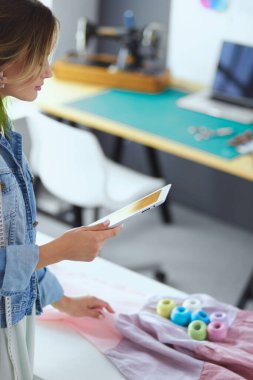 Moda Tasarımcısı kadın stüdyoda tasarımları ile iPad üzerinde.