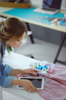 Moda tasarımcısı kadın stüdyoda tasarımları üzerinde çalışıyor..