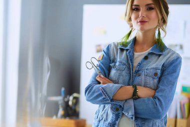 Moda tasarımcısı kadın stüdyoda tasarımları üzerinde çalışıyor..