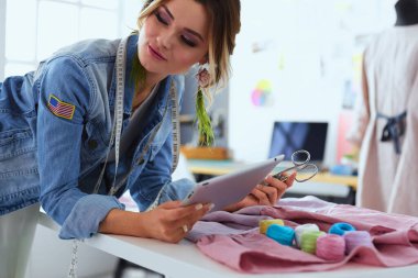 Moda tasarımcısı kadın stüdyoda tasarımları üzerinde çalışıyor..