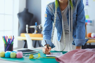 Moda tasarımcısı kadın stüdyoda tasarımları üzerinde çalışıyor..