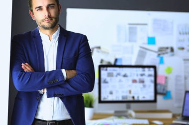 Dizüstü bilgisayar ve bilgisayar çalışırken önünde genç tasarımcı portresi