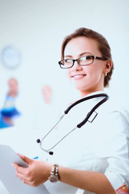 Genç bayan doktor hastanede steteskopla dikiliyor..