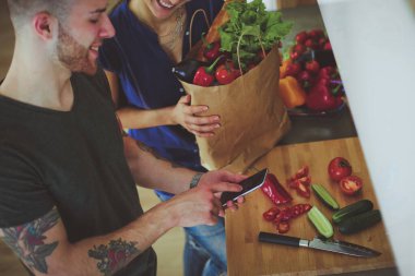 Bir çift evdeki mutfaklarında birlikte yemek pişiriyor..