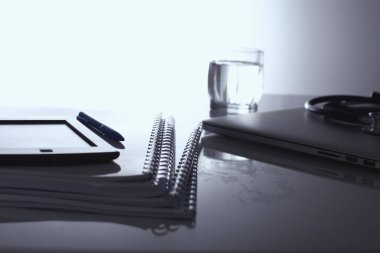 Beyaz arkaplanda dizin yığını olan dizüstü bilgisayar.