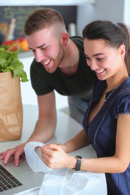 Çift evde mutfak içinde laptop ile onların fatura ödeme.