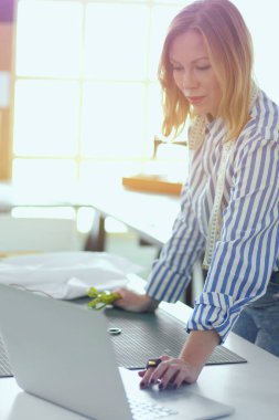 moda tasarımcısı olarak stüdyonun tasarımları üzerinde çalışıyor.