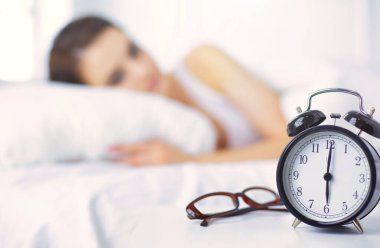 Genç ve güzel bir kadın yatakta yatıyor.