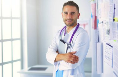 Bilgisayarlı bir erkek doktorun portresi revirde oturuyor.