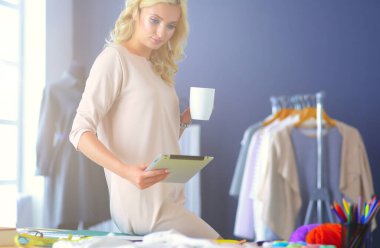 Moda tasarımcısı kadın stüdyoda tasarımları üzerinde çalışıyor.