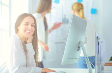 Ofisinde kulaklık ve bilgisayarla gülümseyen iş kadını ya da yardım hattı operatörü.