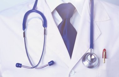 Diş kliniğinde duran gülümseyen bir dişçinin portresi..