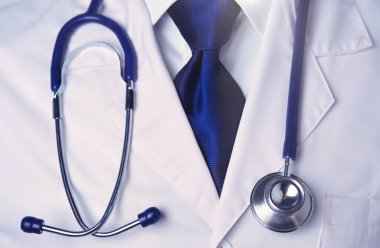 Diş kliniğinde duran gülümseyen bir dişçinin portresi..