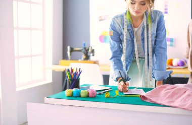 Moda tasarımcısı kadın stüdyoda tasarımları üzerinde çalışıyor..