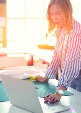 moda tasarımcısı olarak stüdyonun tasarımları üzerinde çalışıyor.