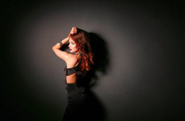 Siyah elbiseli, akşam makyajlı güzel bir kadın..