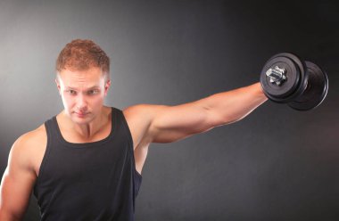 yakışıklı kaslı adam dumbell ile çalışma dışarı.