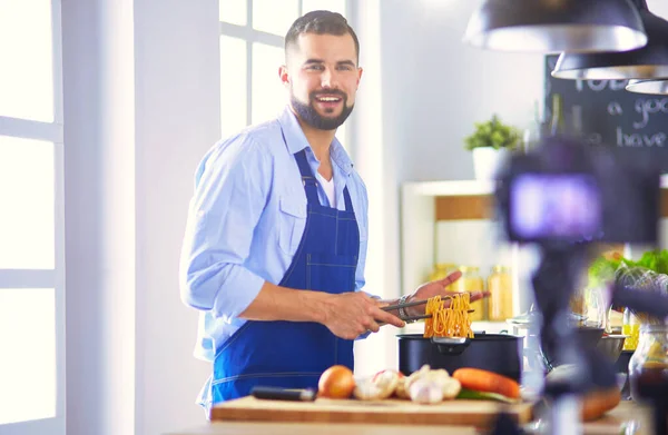 台所の背景に食料品でいっぱいの紙袋を持っている男 買い物と健康食品のコンセプト — ストック写真