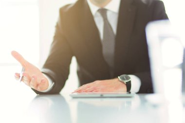 Ofisteki masasında oturan genç adamın portresi.