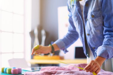 Moda tasarımcısı kadın stüdyoda tasarımları üzerinde çalışıyor..