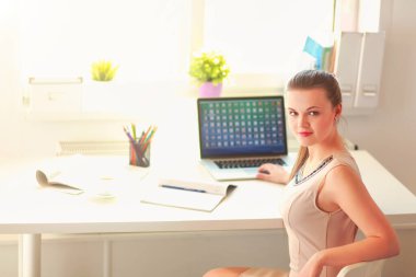 Masasında kulaklığı ve laptopuyla çalışan güzel bir iş kadını. .