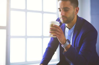 Bir fincan kahve ya da çay içen genç iş adamı..
